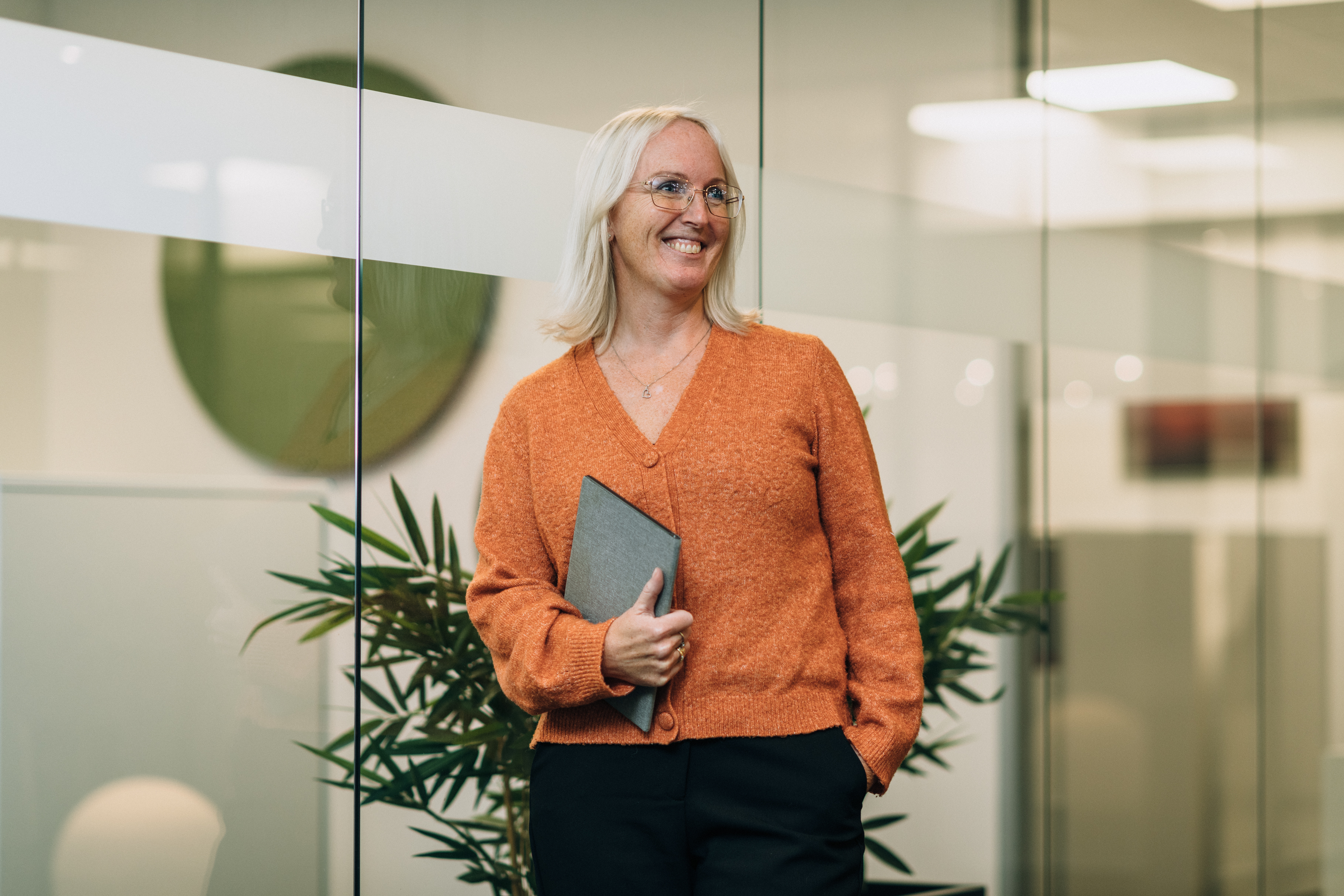 En kvinna står på ett kontor och håller en surfplatta.